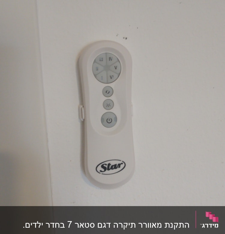 שלט רחוק לבן עם כפתורים על קיר לבן